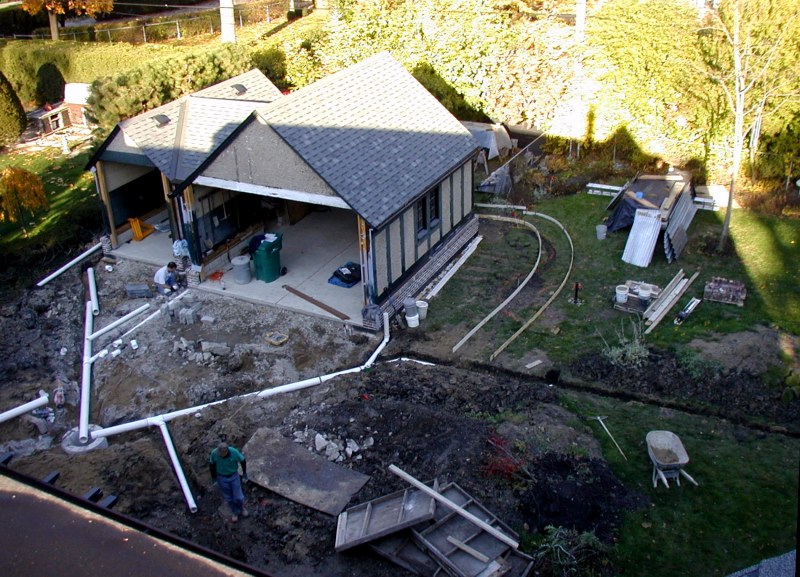 Aerial view of system with plumber preparing for garage downspout connection.