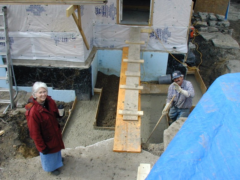 Footer for rear steps is poured March 26. Carol and Jack ensure top of footers are level and more reinforcement is embedded.