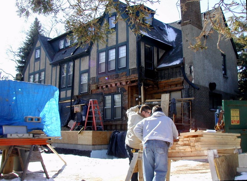 Chris and Kevin review blueprints on February 19. Eventually, the second storey will be supported by steel beams, allowing an enlarged, open room below.