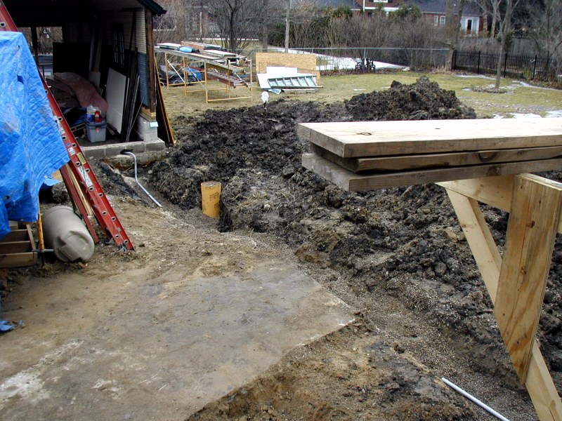 Branch of yard hydrant trench carries garage electrical conduit.